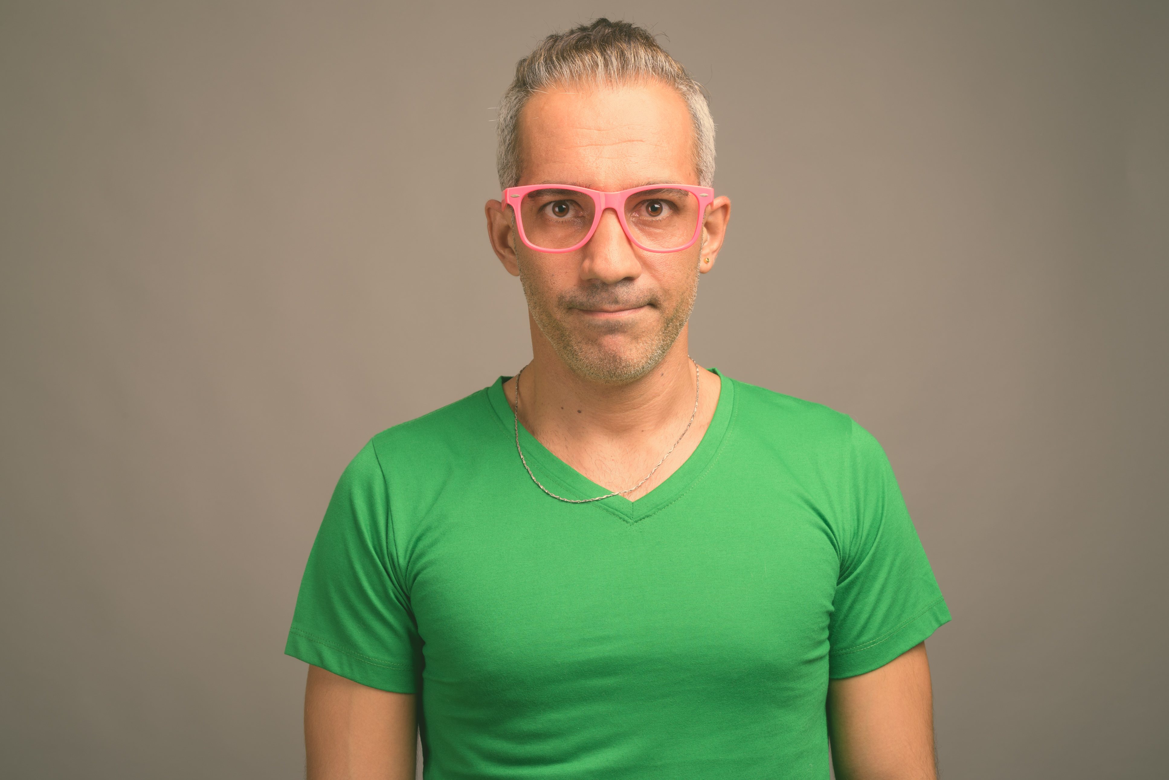 Handsome persian man with gray hair against gray background